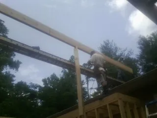 Carpenter setting a ridge beam over a new addition frame — Ice Dam Removal by Roofing Brothers in Washingtonville